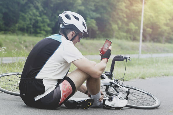 man alongside bike checking his phone