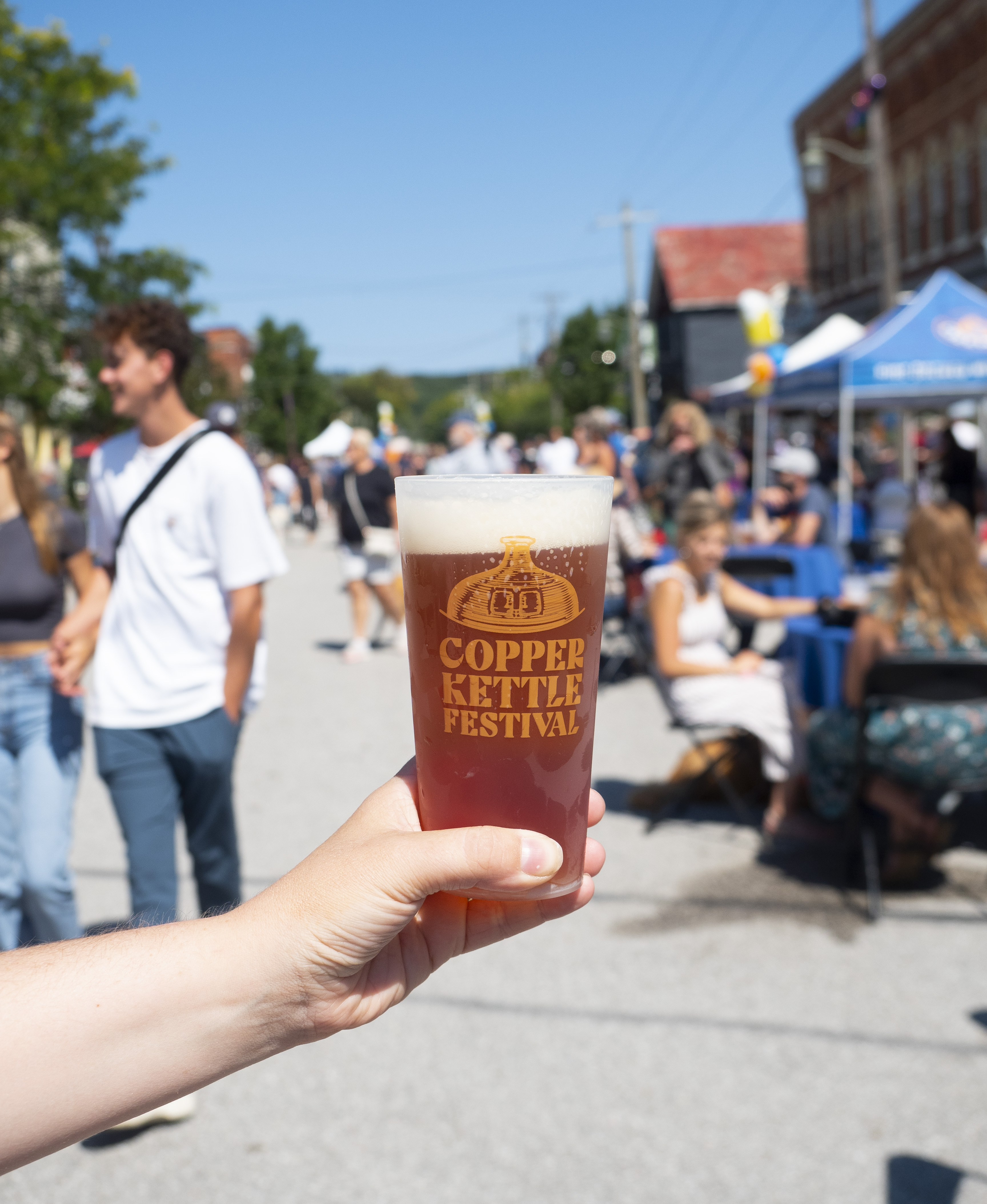 hand with beer in a can on copper kettle festival