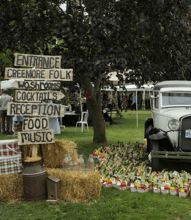 event signage, backdrop tree and classic car with vegetable baskets