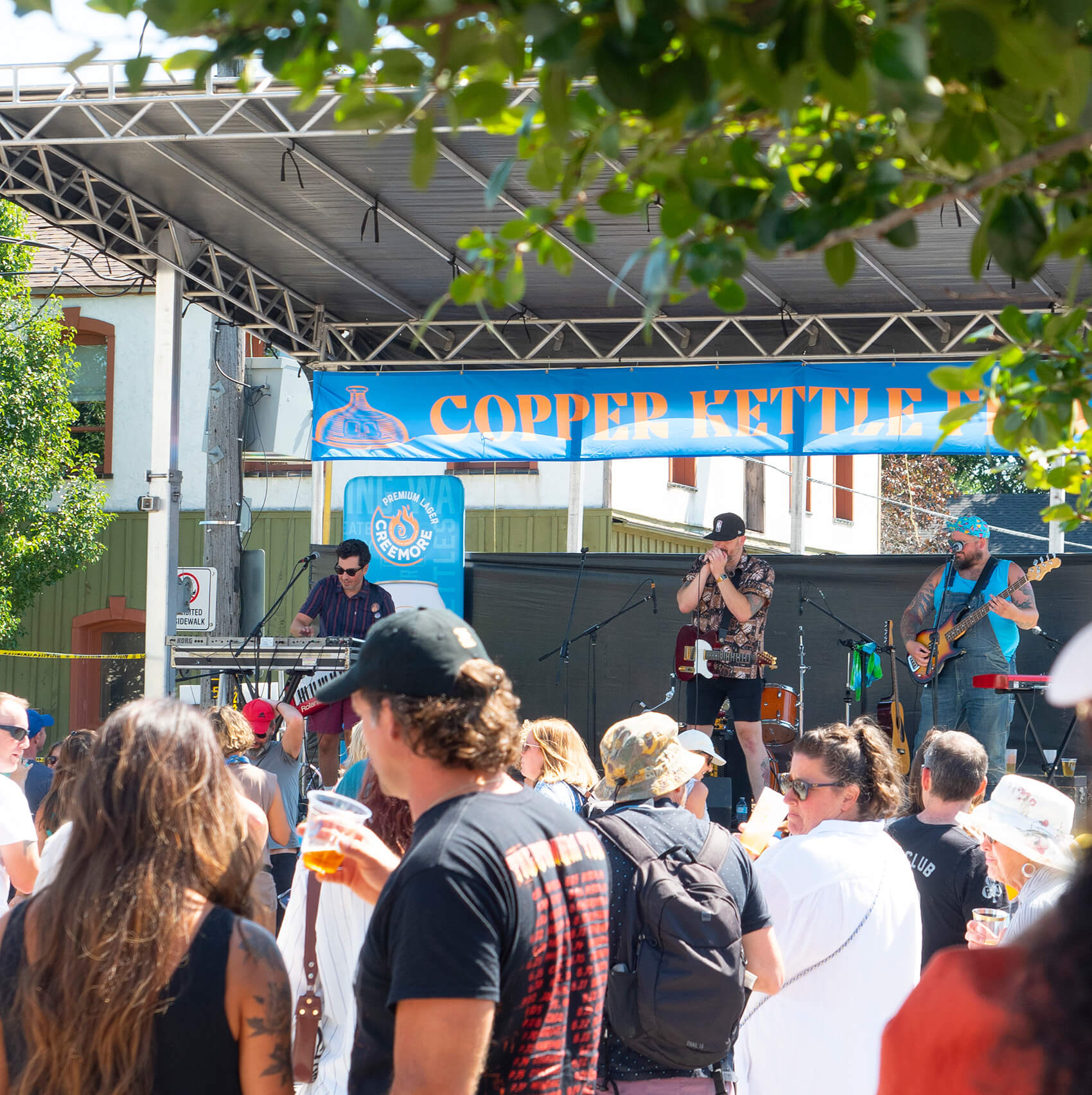 three guys playing the guitar and piano at a concert, people watching the show