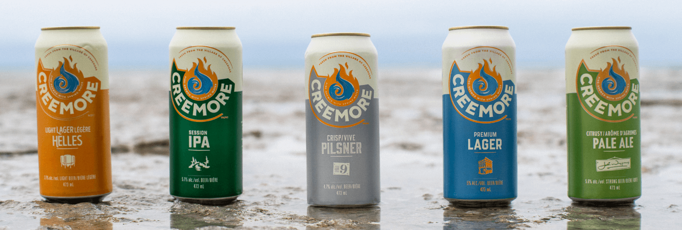 creemore beer cans in a beach