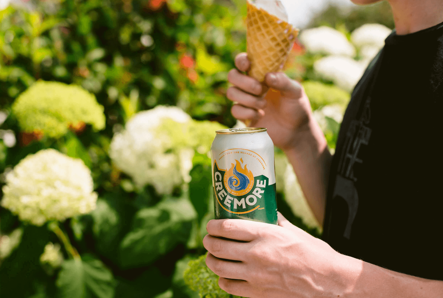 person with a Boundless IPA can in a hand and ice cream in another hand